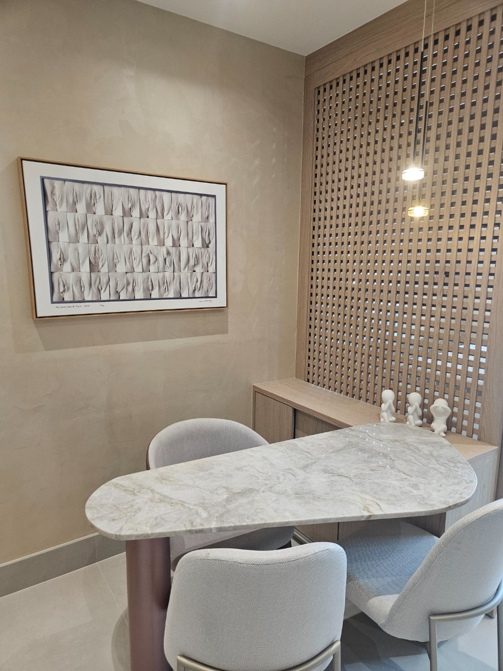 Sala de consulta da Flèr, com mesa de mármore e cadeiras claras