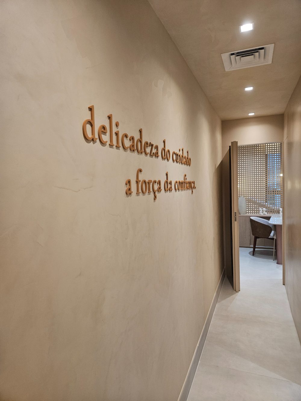 Corredor da Flèr, com a frase “delicadeza do cuidado, a força da confiança” aplicada na parede