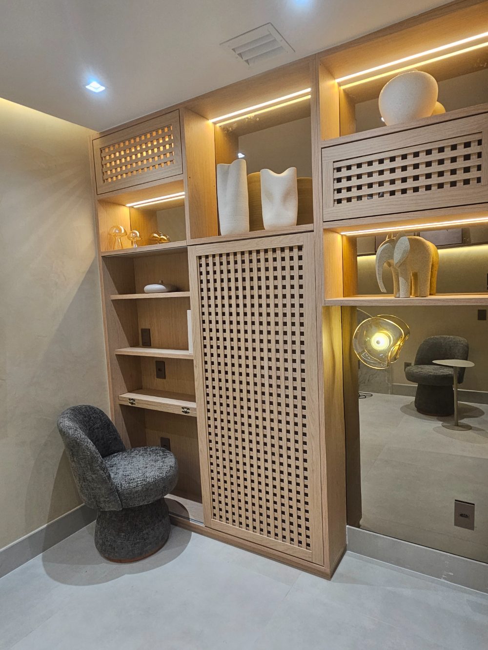 Sala de fisioterapia da Flèr, com estante de madeira iluminada e poltrona